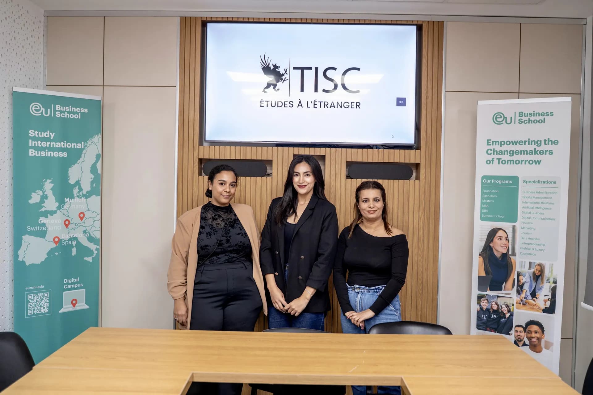 Équipe TISC devant l’écran TISC lors d’un évènement EU Business School
